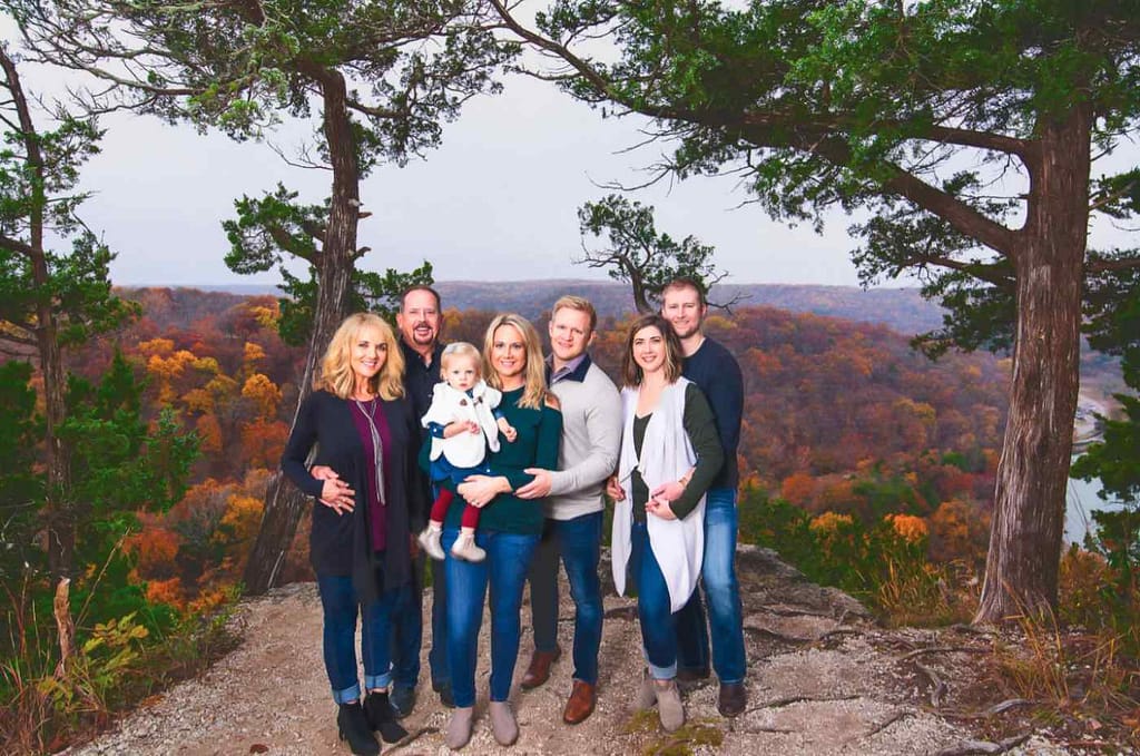 Family portrait photography shot at Lake of the Ozarks with autumn trees in the background