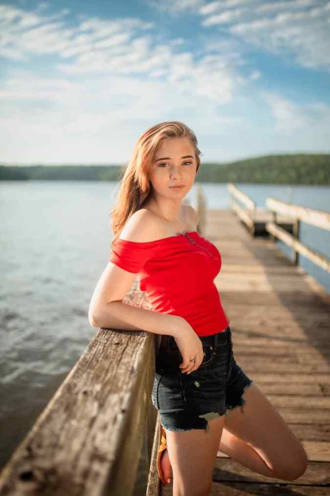 Senior photoshoot on a dock at lake of the ozarks, teenage girl in red top and shorts