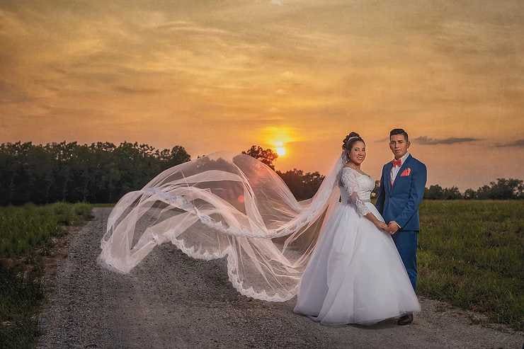 Wedding photoshoot with couple at sunset and the bride's train flowing in the breeze